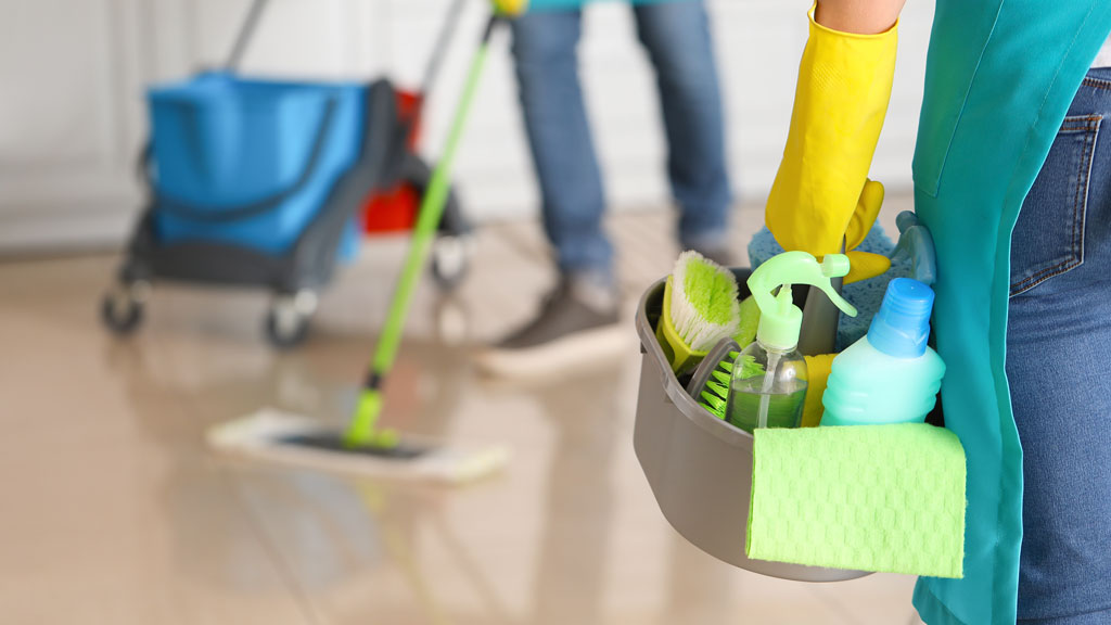 Organized professional cleaning equipment in commercial office hallway